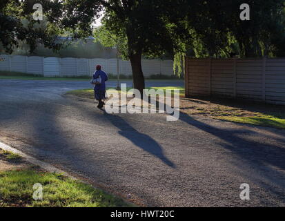 Schwarzen Arbeiter Fuß zur Arbeit durch einen Vorort in Südafrika nach der Apartheid aufgrund des Fehlens von ÖPNV-Infrastruktur Stockfoto