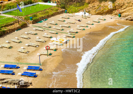 Sandy Evita und Karavostasi Strand im Meer, die Bucht von Bali Resort Dorf. Blick auf Küste, umspült von Wellen und Liegestühle mit Sonnenschirmen Sonnenbaden wo t Stockfoto