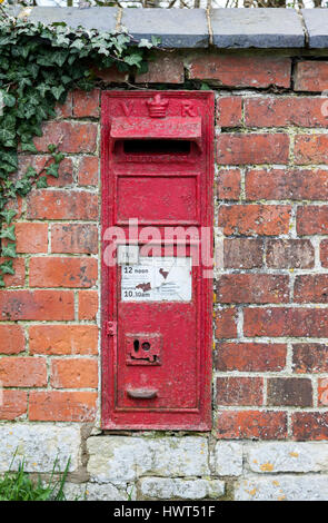 Traditionelles altes rotes Postfach in einer roten Backsteinmauer im Dorf Knook, Wiltshire, England, Großbritannien Stockfoto