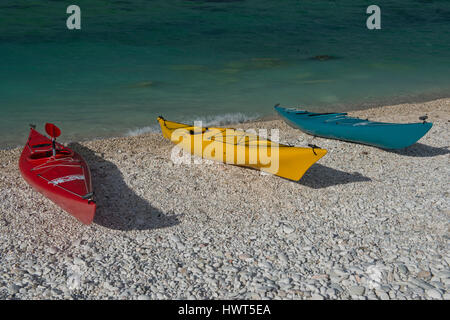 Drei bunte Kanus liegen auf dem Strand von Portonovo Stockfoto