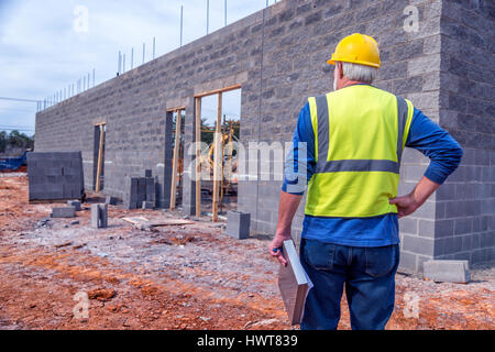 Ein grauhaariger Supervisor prüft Neubau Einzelhandel. Stockfoto