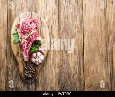 Rindersteak mit Gewürzen auf Holzbrett. Stockfoto