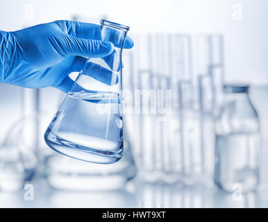 Labor-Becher in der Hand des Analytikers in Kunststoff-Handschuh. Stockfoto