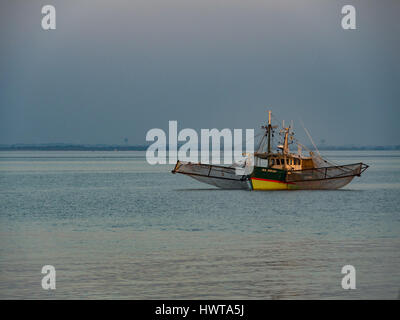 72/5000 letzten Strahlen der Sonne auf einem Garnelen-Boot in der Mündung der Gironde (Hafen von La Maréchale) verankert. Stockfoto