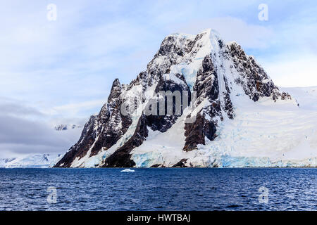 Großen Stein Felsen bedeckt mit Schnee und Meer im Vordergrund, in der Nähe von argentinischen Inseln, Antarktis Stockfoto