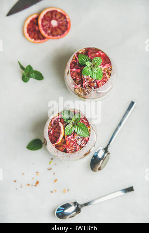 Gesundes Frühstück mit Joghurt, Müsli, orange geschichteten Parfait in Gläsern Stockfoto