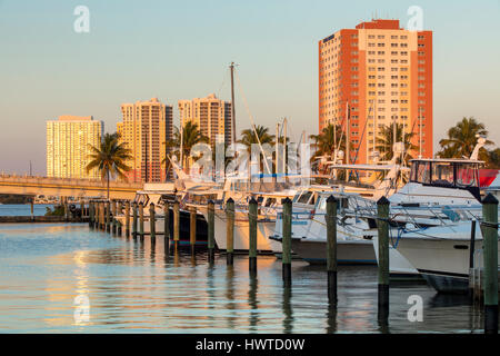 Boote vor Anker in Fort Myers Yacht Basin mit Eigentumswohnung Türme über Fort Myers, Florida, USA Stockfoto