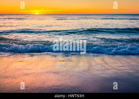 Wellen und Sonnenuntergang über Meer am Glenelg Beach, South Australia Stockfoto