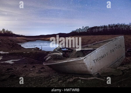 Unter einem Sternenhimmel bleibt ein altes verlassenes Boot am Ufer des Summersville See, im Winter abgelassen.  Schuss in West Virginia. Stockfoto