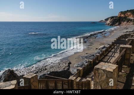 Strand am Mittelmeer mit türkisblauem Meer und Felsen Abstieg zum Meer und Treppe zum Meer am sonnigen Tag erschossen Stockfoto