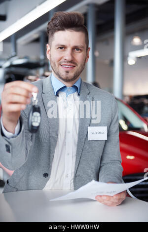 Verkäufer mit Autoschlüssel vor der Kamera Stockfoto