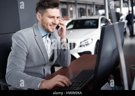 Kfz-Händler am Telefon Gespräch mit Kunden Stockfoto