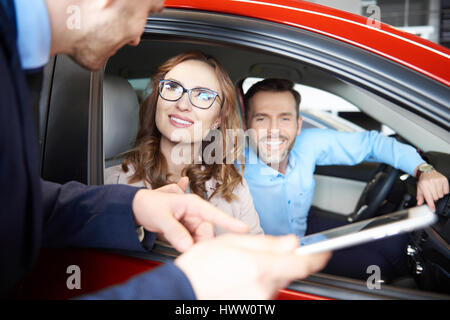 Verkäufer mit Handy während der Auto Verkauf Stockfoto