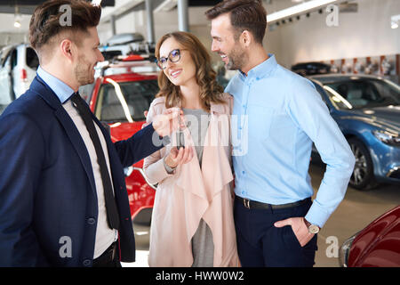 Schlüsselübergabe paar brandneue Auto Verkäufer Stockfoto