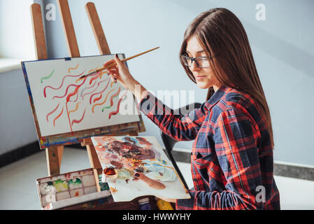 Pretty Pretty Girl Künstler malt auf Leinwand Gemälde auf der Staffelei. Modell im studio Stockfoto