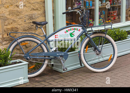 Cirencester - Fahrrad außerhalb Krokodil-Spielzeug-Shop auf dem Wollmarkt, Cirencester, Gloucestershire im März Stockfoto