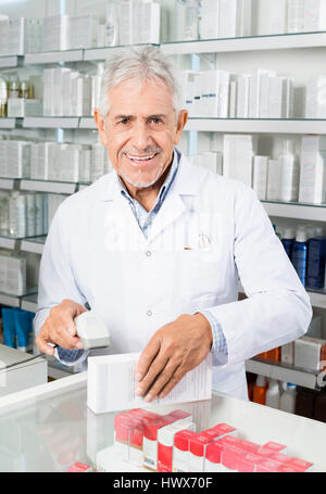 Porträt von senior männlichen Chemiker Scannen von Barcodes auf Medizin-Box in der Pharmazie Stockfoto