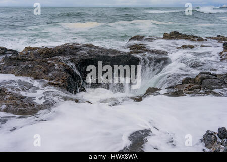 Thor's Well in Yachats, Oregon ist eine 20 ft. Höhle, in der Wellen ein- und ausbrechen, manchmal in der Luft schießen. Stockfoto