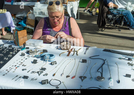 Eine Frau, die Herstellung von Schmuck auf einem Marktstand in der Markthalle bei Tynemouth im Nordosten Englands. Stockfoto