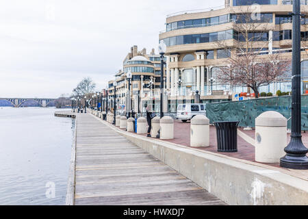 Washington DC, USA - 20. März 2017: Georgetown Hafen tagsüber am Flussufer mit Promenade, Gebäude und wichtige Brücke mit Potomac river Stockfoto