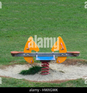 Doppelsitze rockt Frühjahr Pferd auf der Wiese eines Spielplatzes Stockfoto