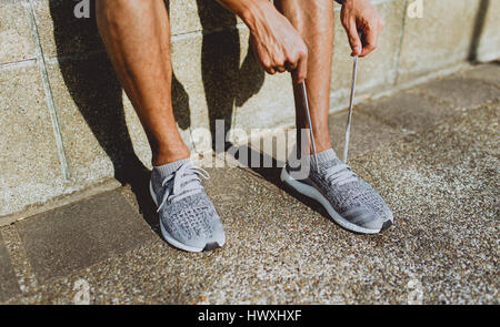 Läufer, die Schnürsenkel, die Vorbereitungen für den Lauf zu binden. selektiven Fokus auf der Seite. Stockfoto