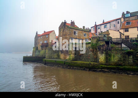 Blick auf Staithes Außenhafen an einem leicht nebligen Tag bei Flut. Stockfoto