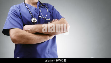 Arzt in Scrubs Gelenkarme mit Stethoskop und grauen Hintergrund für Kopie Stockfoto