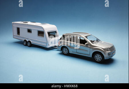 Spielzeugauto Abschleppen eine Karawane von generischen Design auf blauem Hintergrund Stockfoto