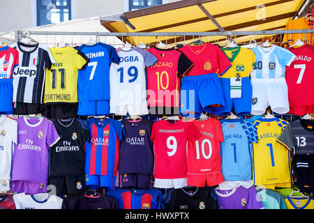 Ein Marktstand im Freien mit einer Auswahl an nachgebildeten Fußballtrikots für Kinder, die auf der Rückseite des Trikots mit verschiedenen Top-Spielernamen versehen sind Stockfoto