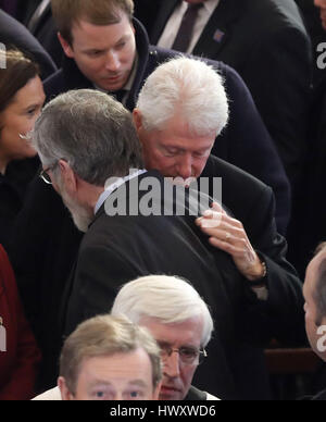 Ehemalige US-Präsident Bill Clinton umarmt Sinn Féin Präsident Gerry Adams nach der Beerdigung von Northern Ireland ehemalige stellvertretende erste Minister und Ex-IRA Kommandant Martin McGuinness im St. Columba Kirche lange Tower in Londonderry. Stockfoto