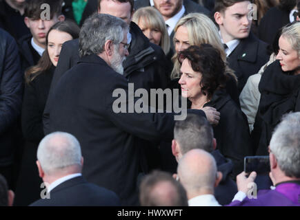 Martin McGuinnesss Frau Bernie ist von Gerry Adams getröstet, St. Columba lange Kirchturm, in Londonderry, verlassen, nach der Trauerfeier der Nordirland ehemalige stellvertretende erste Minister und Ex-IRA Kommandanten Beerdigung. Stockfoto