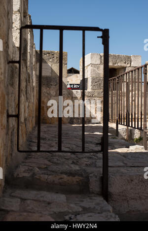 Jerusalem, Israel - 25. Februar 2017: Zeichen-Stadt, die durch die Bars von alten Steinmauern gesehen Stockfoto