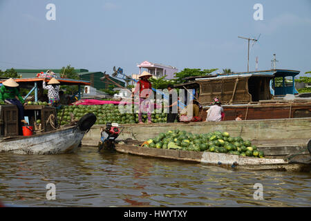 Melone-Verkäufer in den schwimmenden Markt laden Melonen auf ihr Boot auf dem Mekong in Vietnam Stockfoto