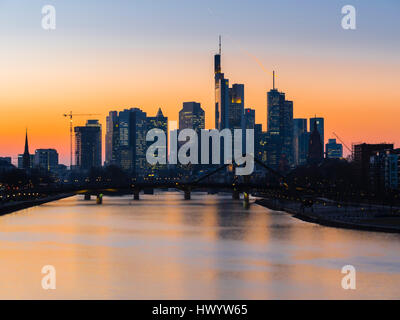 Deutschland, Frankfurt am Main, Blick auf Skyline mit Floesserbruecke und Mains im Vordergrund in der Dämmerung Stockfoto