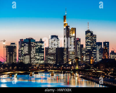 Deutschland, Frankfurt am Main, Blick auf Skyline mit Floesserbruecke und Mains im Vordergrund in der Dämmerung Stockfoto
