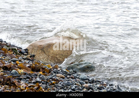Wellen Waschen über einen Felsblock auf einen gepflasterten Strand, wenig Cranberry Island, Maine. Stockfoto