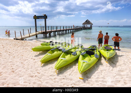 Hölzerne Pier und Kajaks mit Touristen am Sandstrand, Insel Cozumel in Mexiko Stockfoto