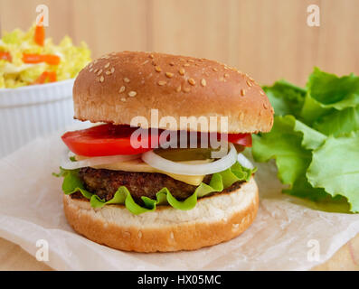 Sandwich nach Hause von der Hamburger Brötchen weiche, saftige Burger, Käse, Tomaten, Petersilie. Wirsing Salat. Fast-Food. Stockfoto