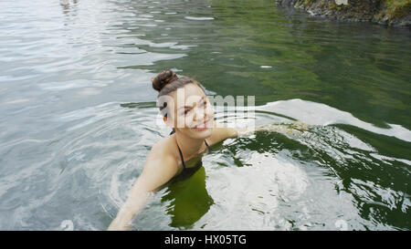 Hohen Winkel Porträt der lächelnde Frau im Bikini schwimmen in abgelegenen Wasserbecken Stockfoto