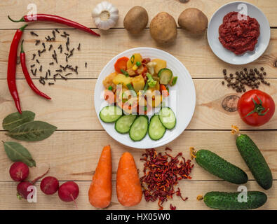 Gemüseeintopf (Kartoffeln, Spargel, Karotten, Rosenkohl, Mais, Erbsen, Wirsing, Brokkoli) in einem weißen Teller. Vegan. Stockfoto