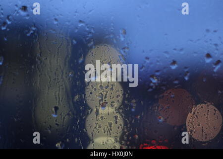 Regentropfen auf ein Fenster Schmerz an einem regnerischen Abend in Cardiff, Wales Stockfoto