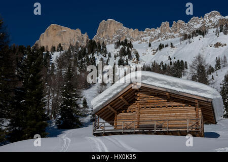 Chalet und Bäume unter dem Schnee in der idyllischen Landschaft des Dolomiti in Trentino-Südtirol Stockfoto