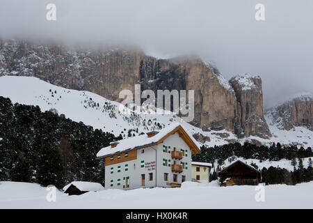 Chalet und Bäume unter dem Schnee in die idyllische Landschaft der Dolomiten im Val di Fassa Stockfoto