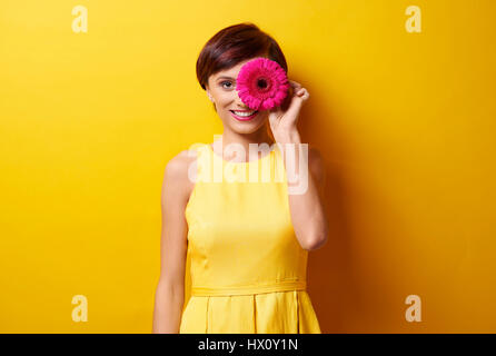 Junge Dame mit Blume vor Auge Stockfoto