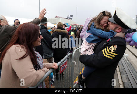 Petty Officer Adam Jeffrey (rechts) wird von seiner Tochter Isabelle, 5, und Frau Luisa (links) begrüßt nach HMS Ocean, Flotte Flaggschiff der Royal Navy an Land aus wie nach HM Naval Base Devonport, Plymouth nach sechs Monaten auf den Betrieb kehrte. Stockfoto