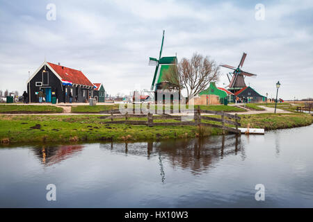 Windmühlen und alten Holzhäusern entlang Fluss Zaan Zaanse Schans Stadt gehört zu den beliebten Sehenswürdigkeiten der Niederlande Stockfoto