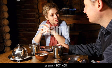 Junges Paar ausdrücklich in einem Café im Chat Stockfoto