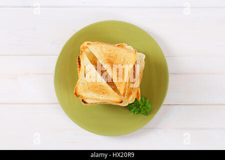Stapel von gerösteten Brotscheiben auf Teller grün Stockfoto