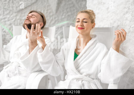 Junges Paar in Bademäntel meditieren in der Salzkammer Stockfoto